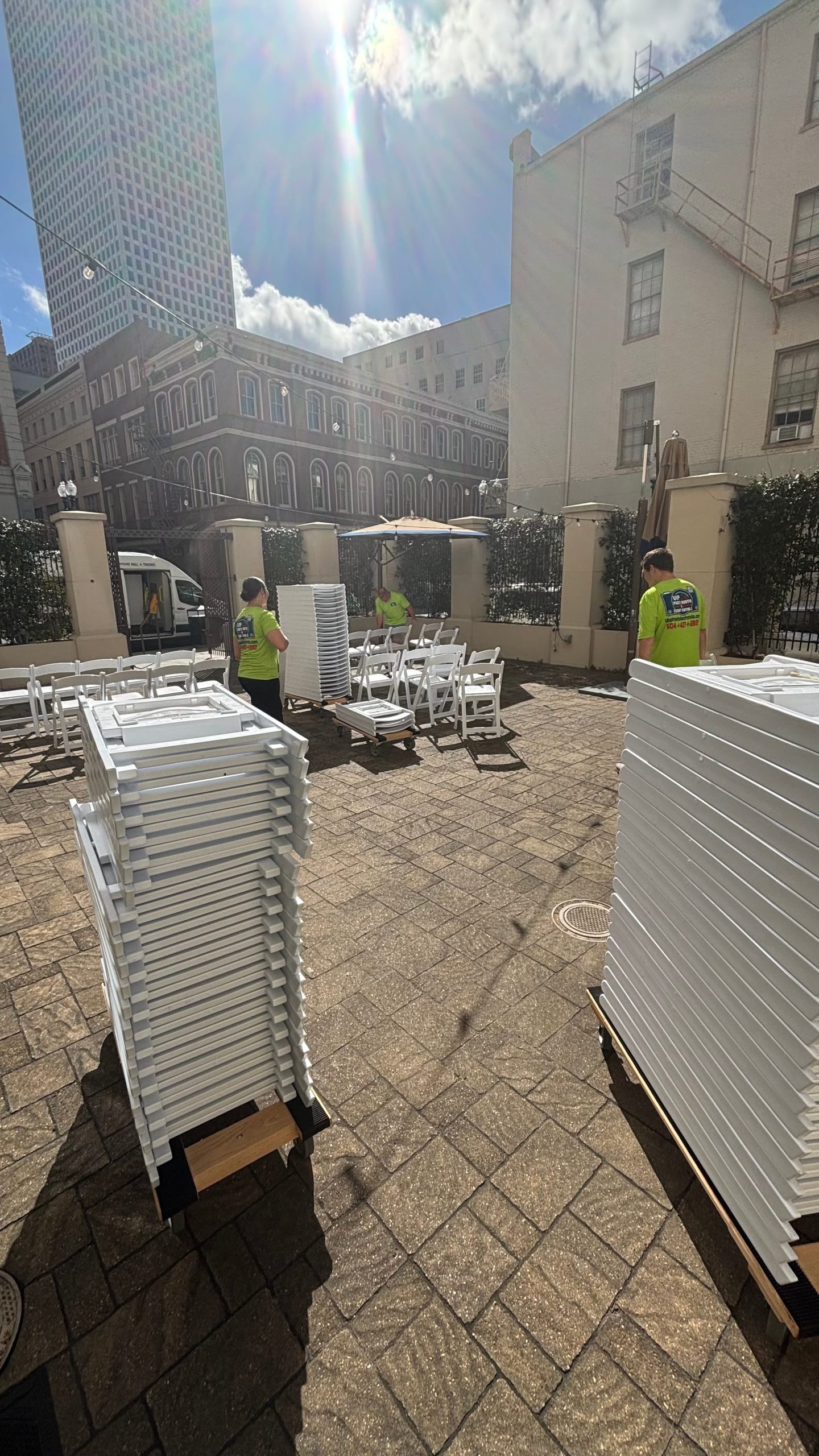 White event chairs stacked up, ready to be set out for event